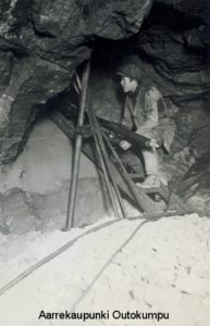 Kaivostyöntekijöitä kalliossa puurakenteiden keskellä