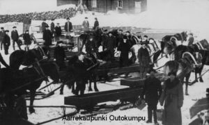 Työmaa, jossa useita hevosia ja miehiä talvimaisemassa